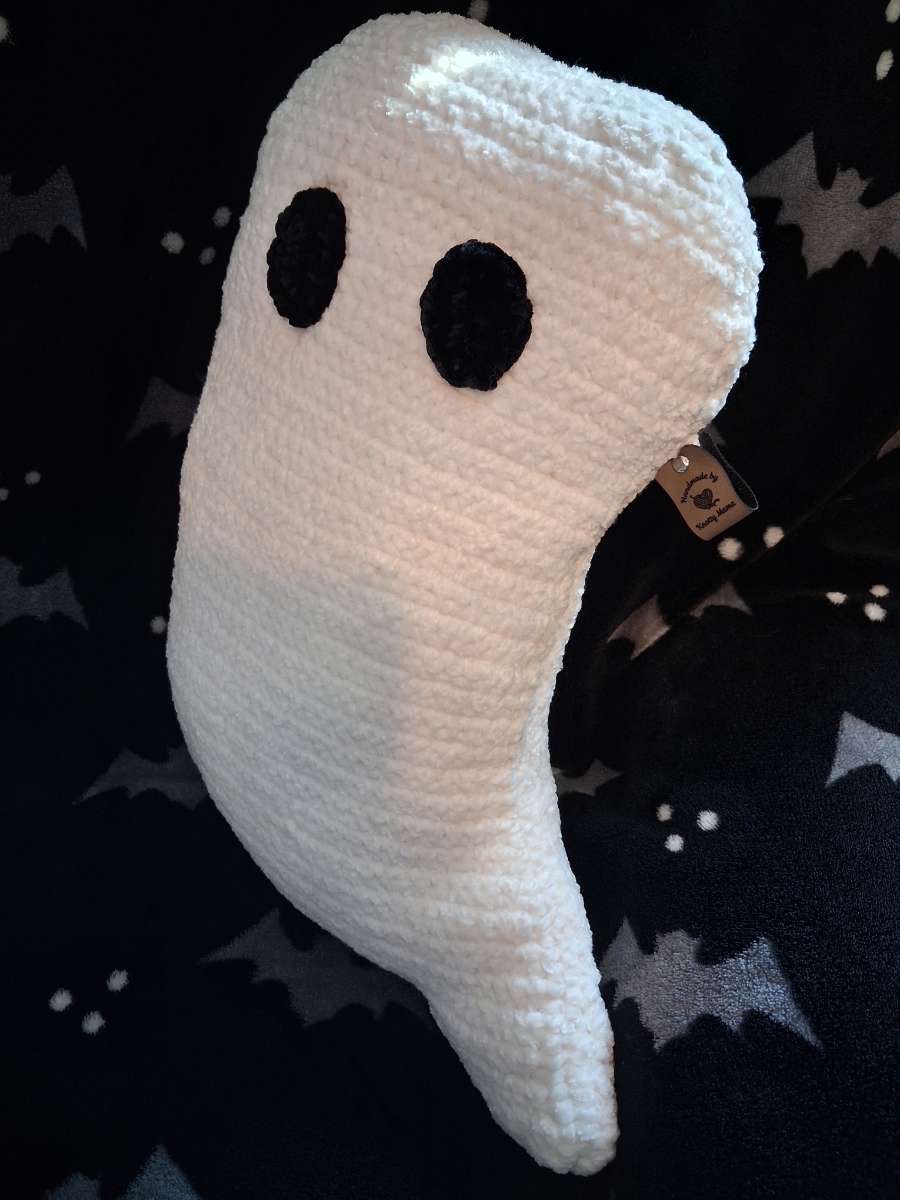 Large white crocheted ghost pillow with big black eyes