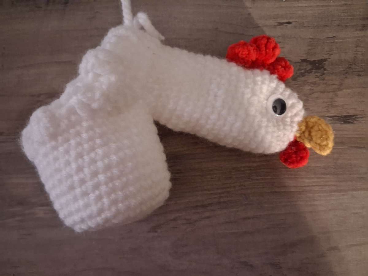 White crocheted rooster-shaped novelty warmer with red comb and yellow beak