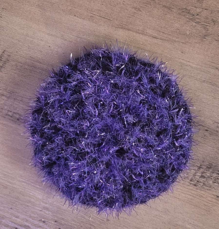 Round purple crocheted dish scrubby made from scrubby yarn