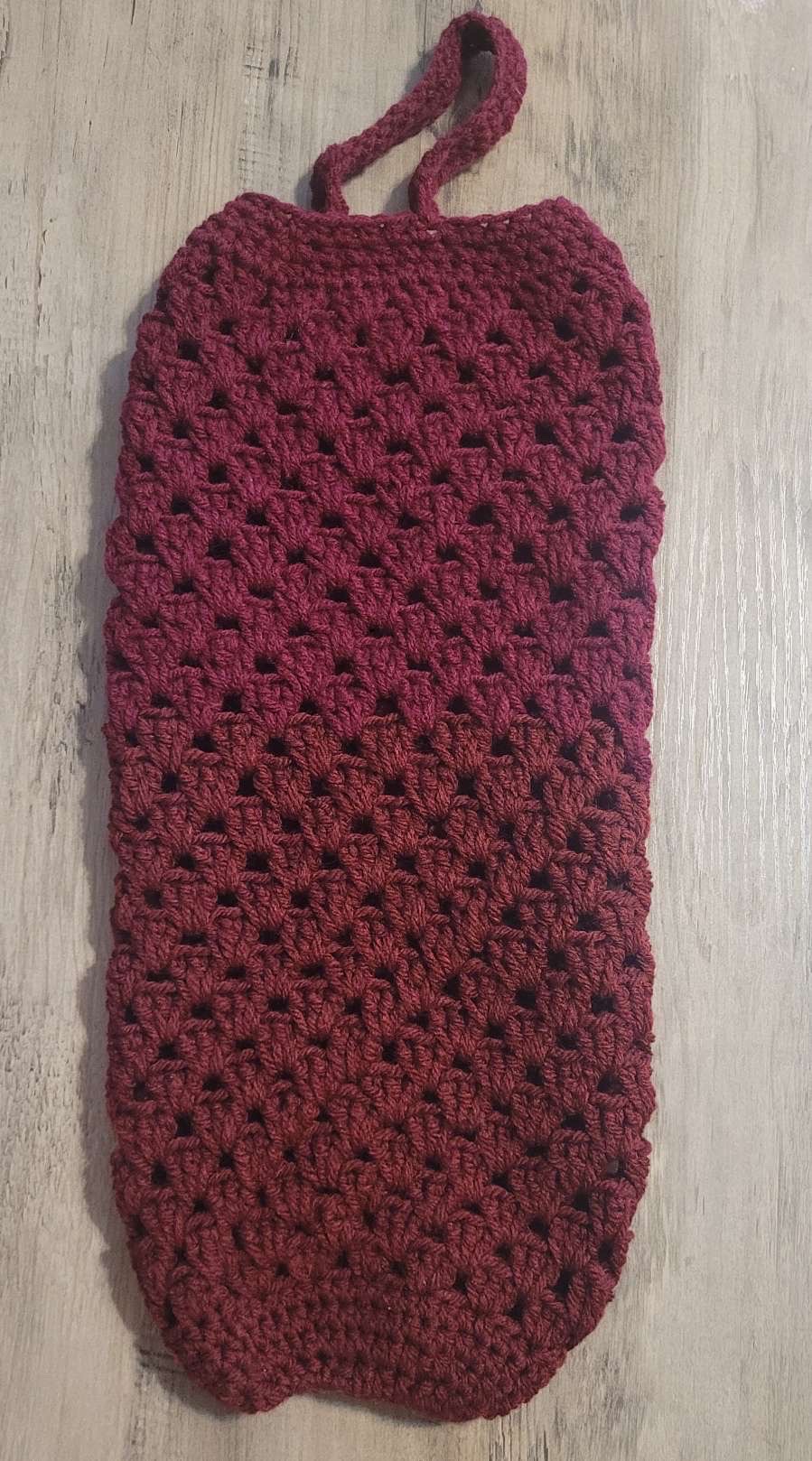 Burgundy crocheted hanging bag holder with open stitch design